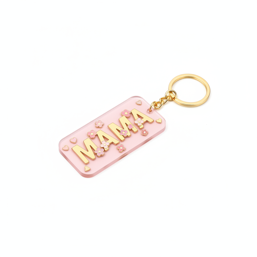 Soft pink acrylic keychain with MAMA in bold block letters decorated with hearts and flowers in pastel pink and gold on white background